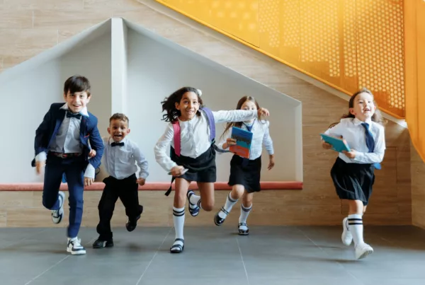 Niños corriendo con material escolar perteneciente a la marca Didex.